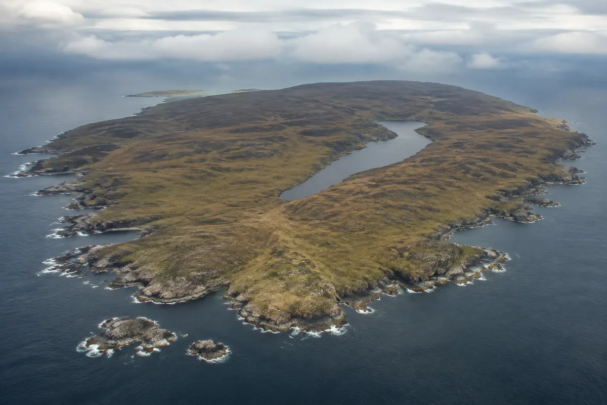 Aerial view of Islay as one distinct island with rocky coast and low inland peatland
